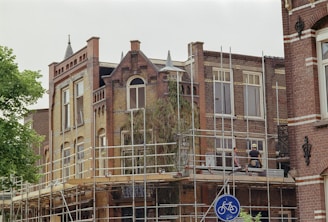 a building with scaffolding around it and a bicycle sign
