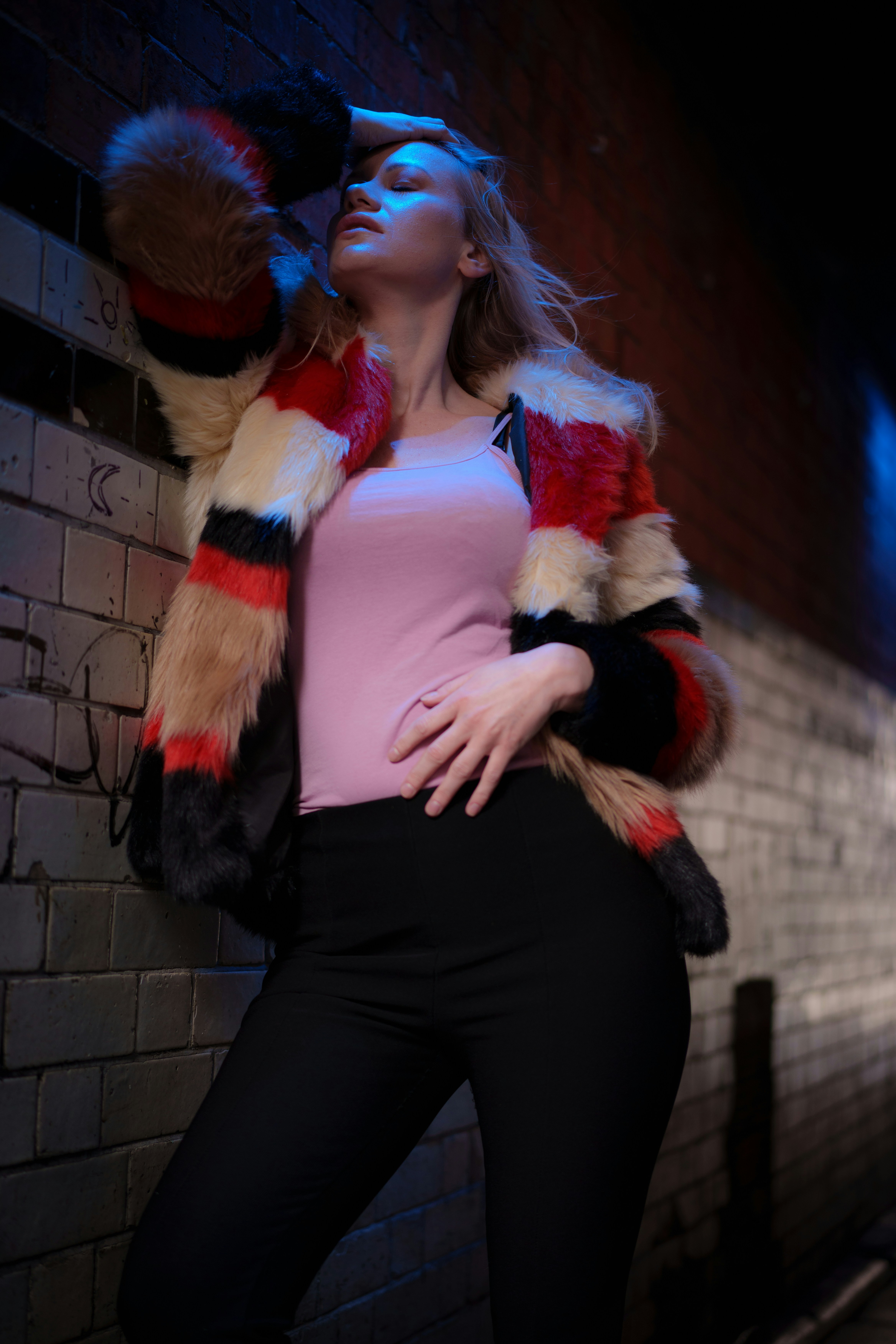 uma mulher ao lado de uma parede de tijolos