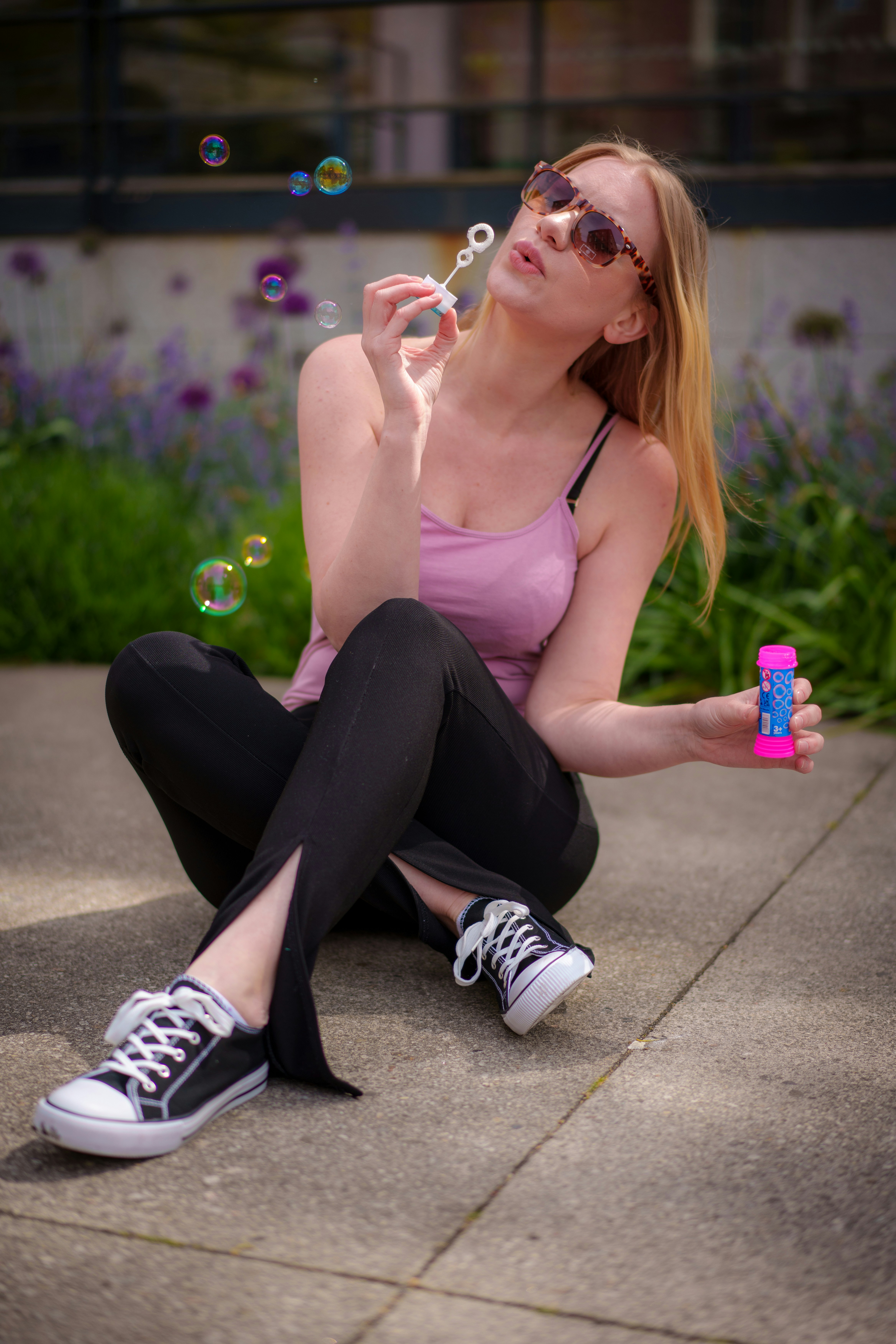 uma mulher sentada no chão soprando bolhas