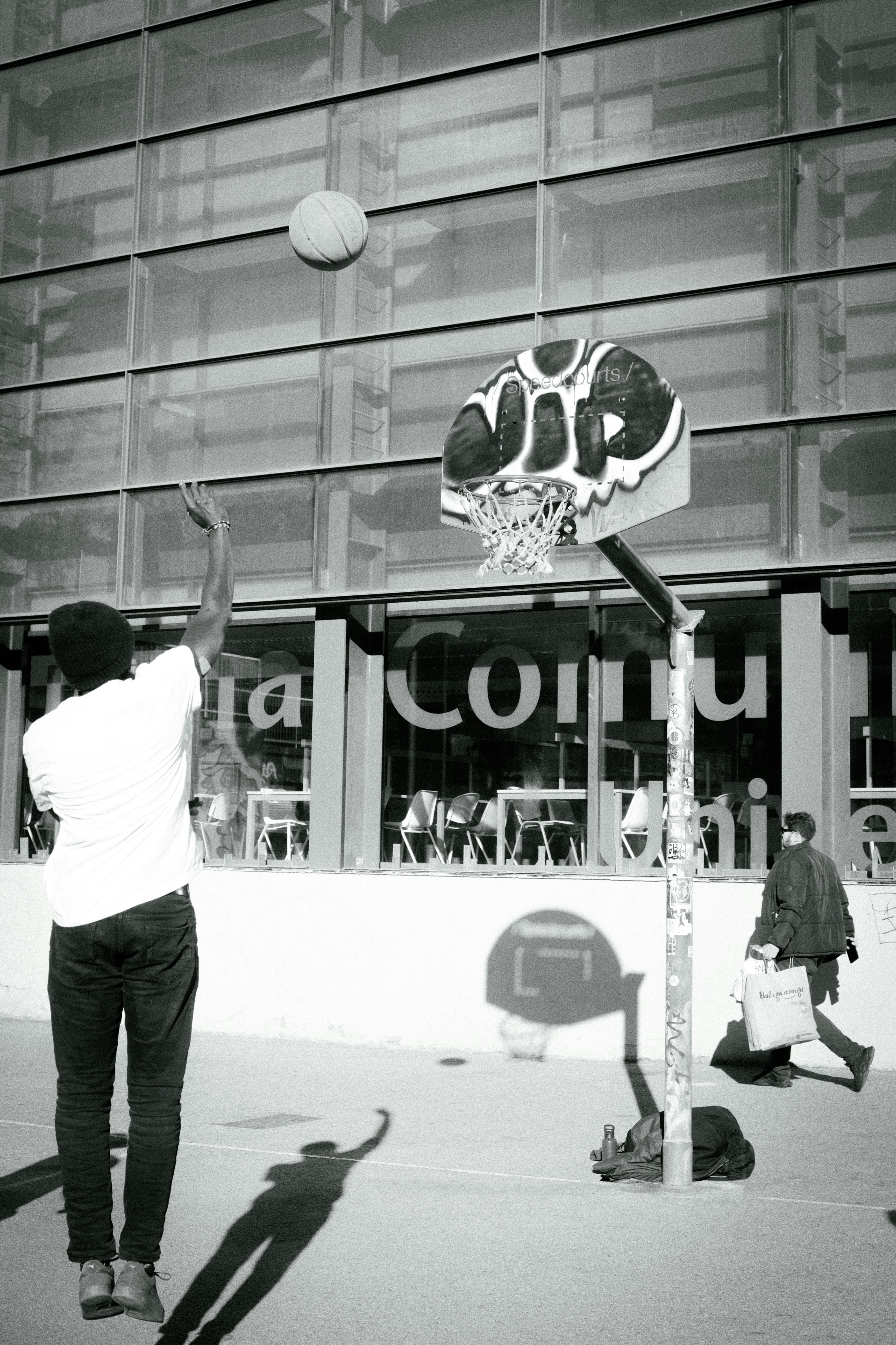 a man playing basketball in front of a building