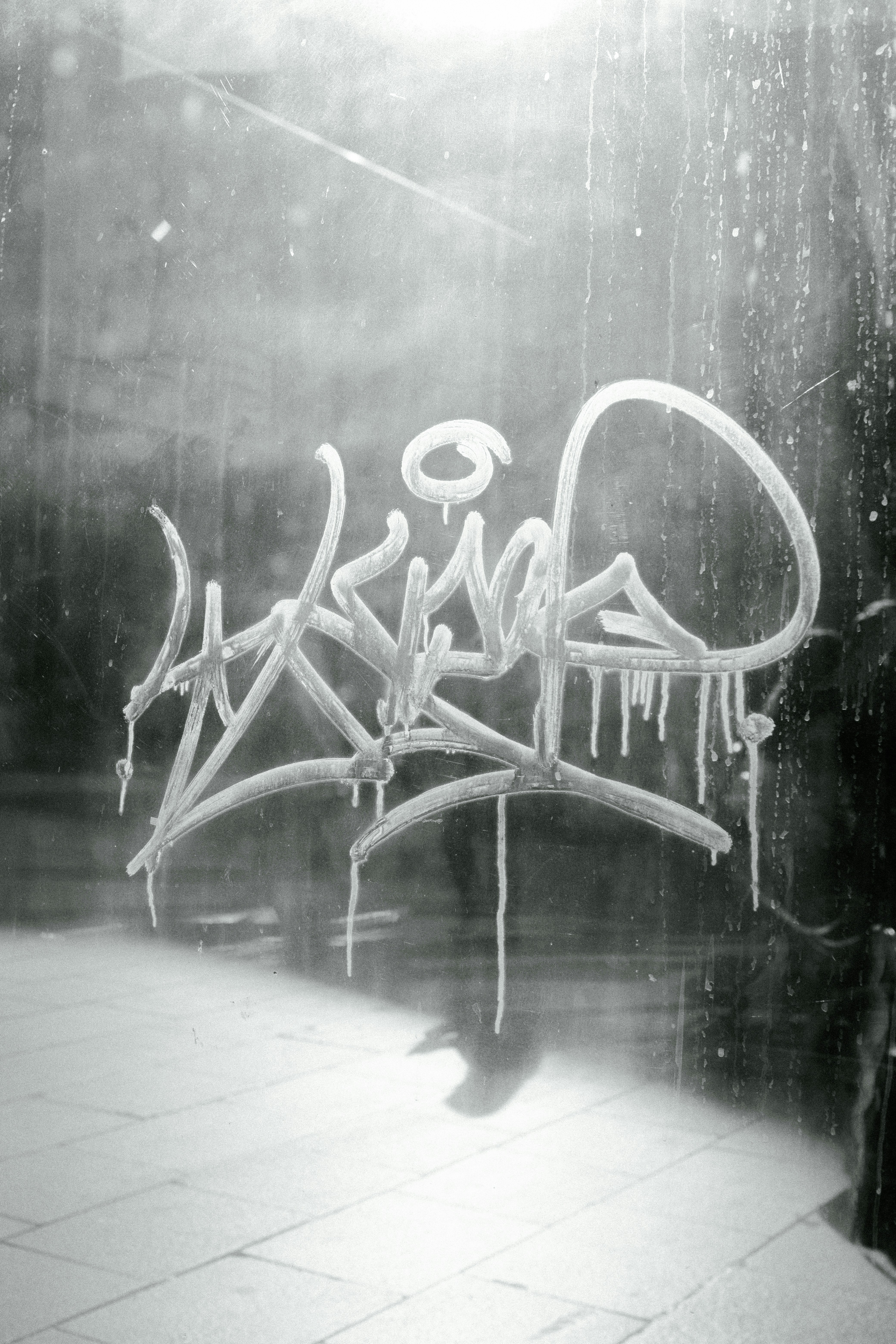 una foto in bianco e nero di graffiti su una finestra
