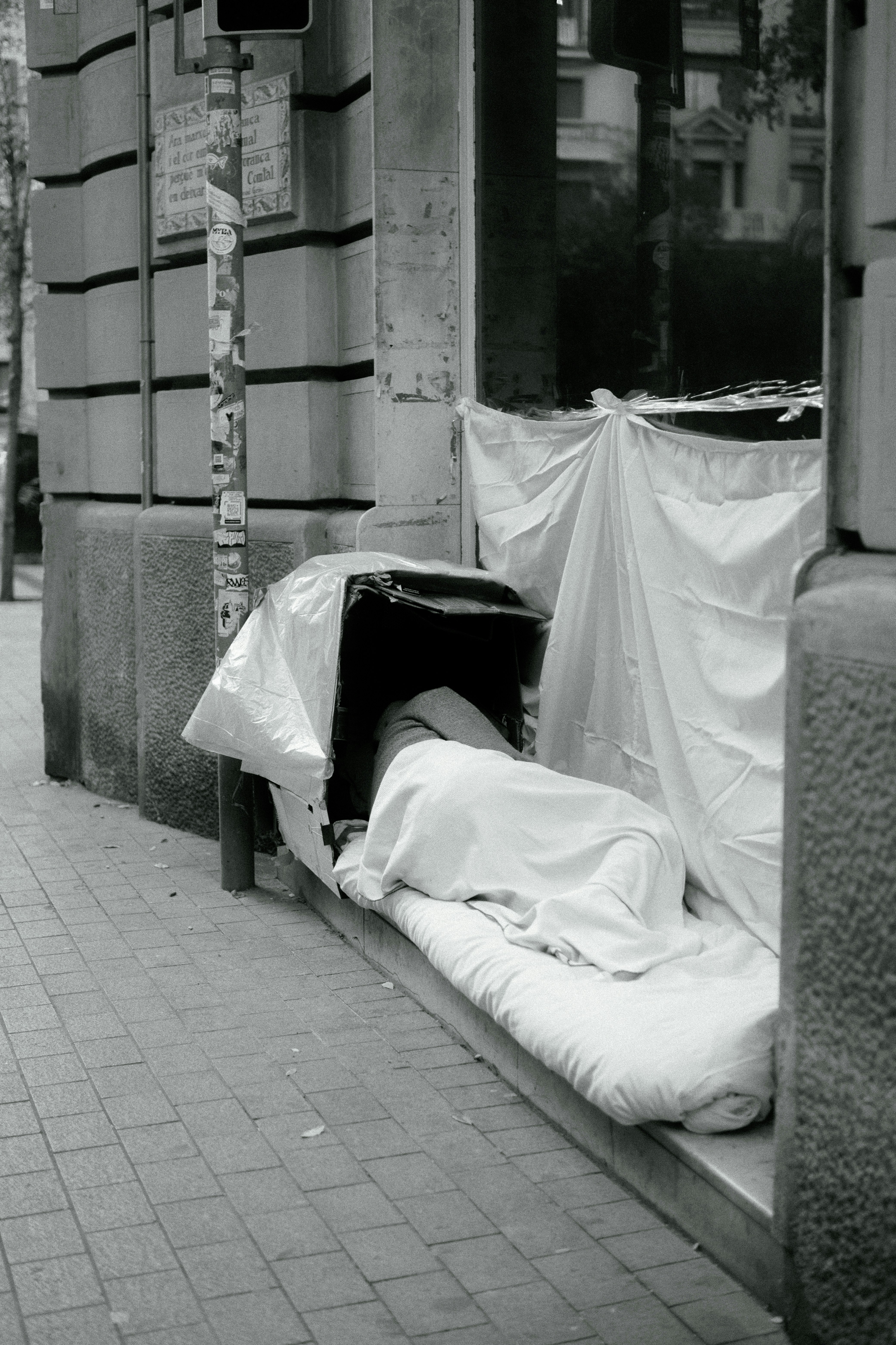 a black and white photo of a mattress on the sidewalk