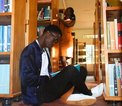 a man sitting on the floor reading a book