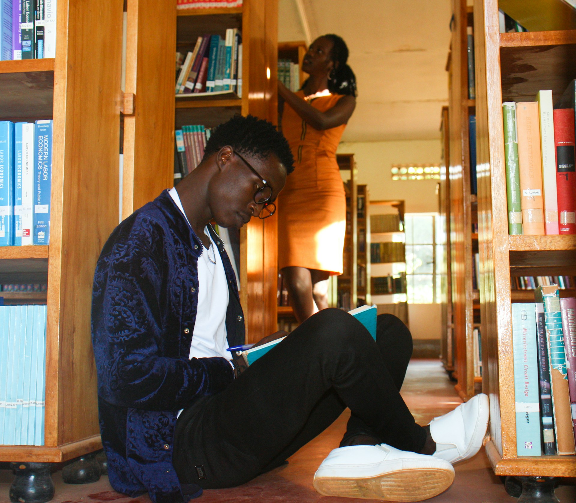 a man sitting on the floor reading a book