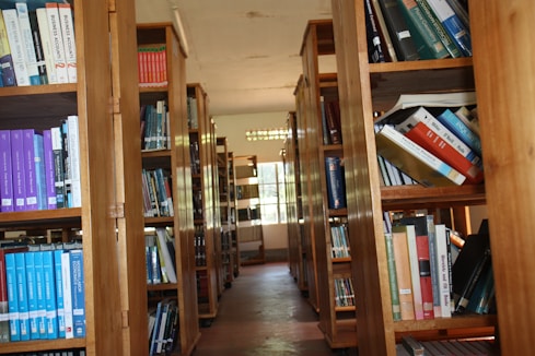 a row of wooden bookshelves filled with lots of books