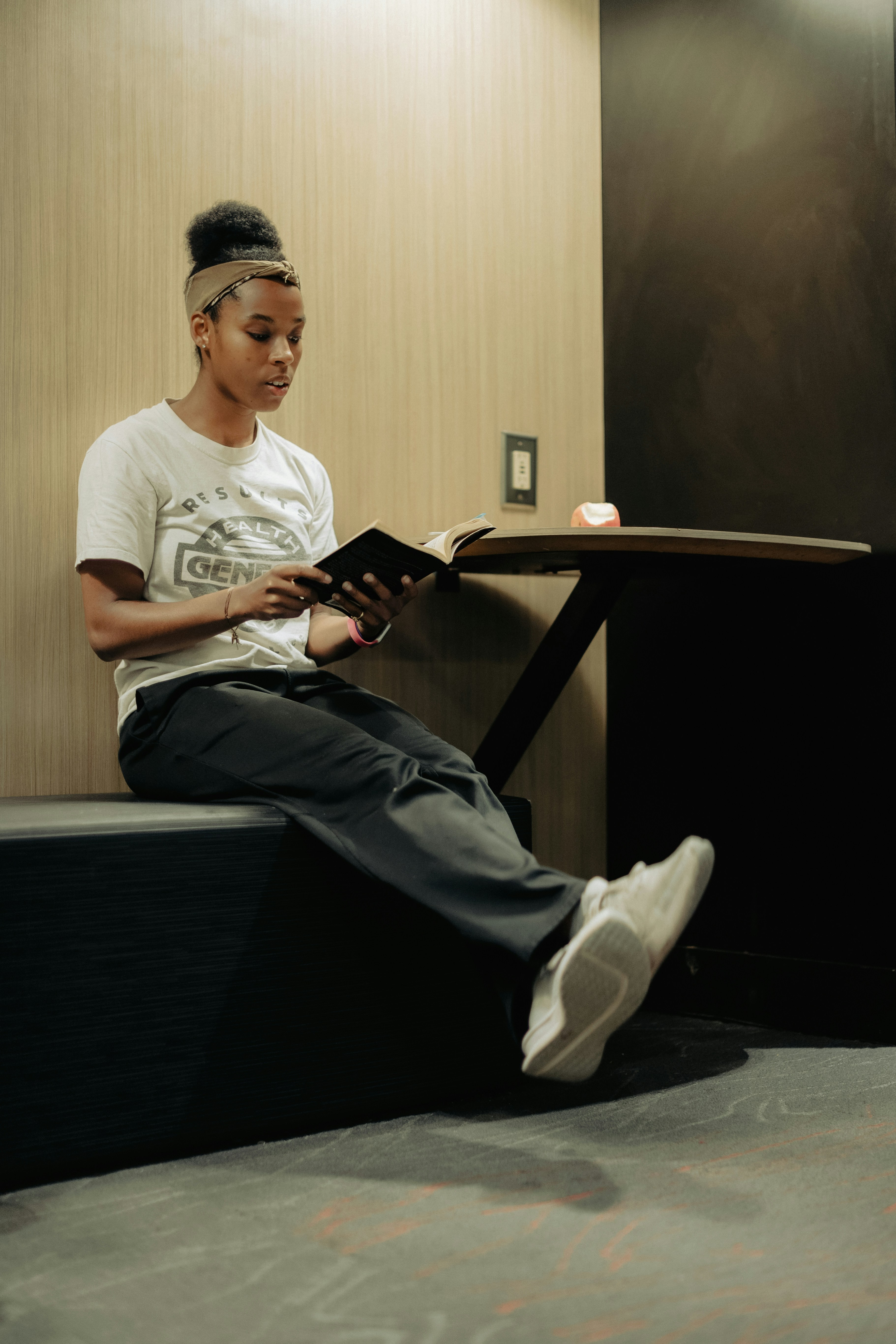 a woman sitting on a bench reading a book