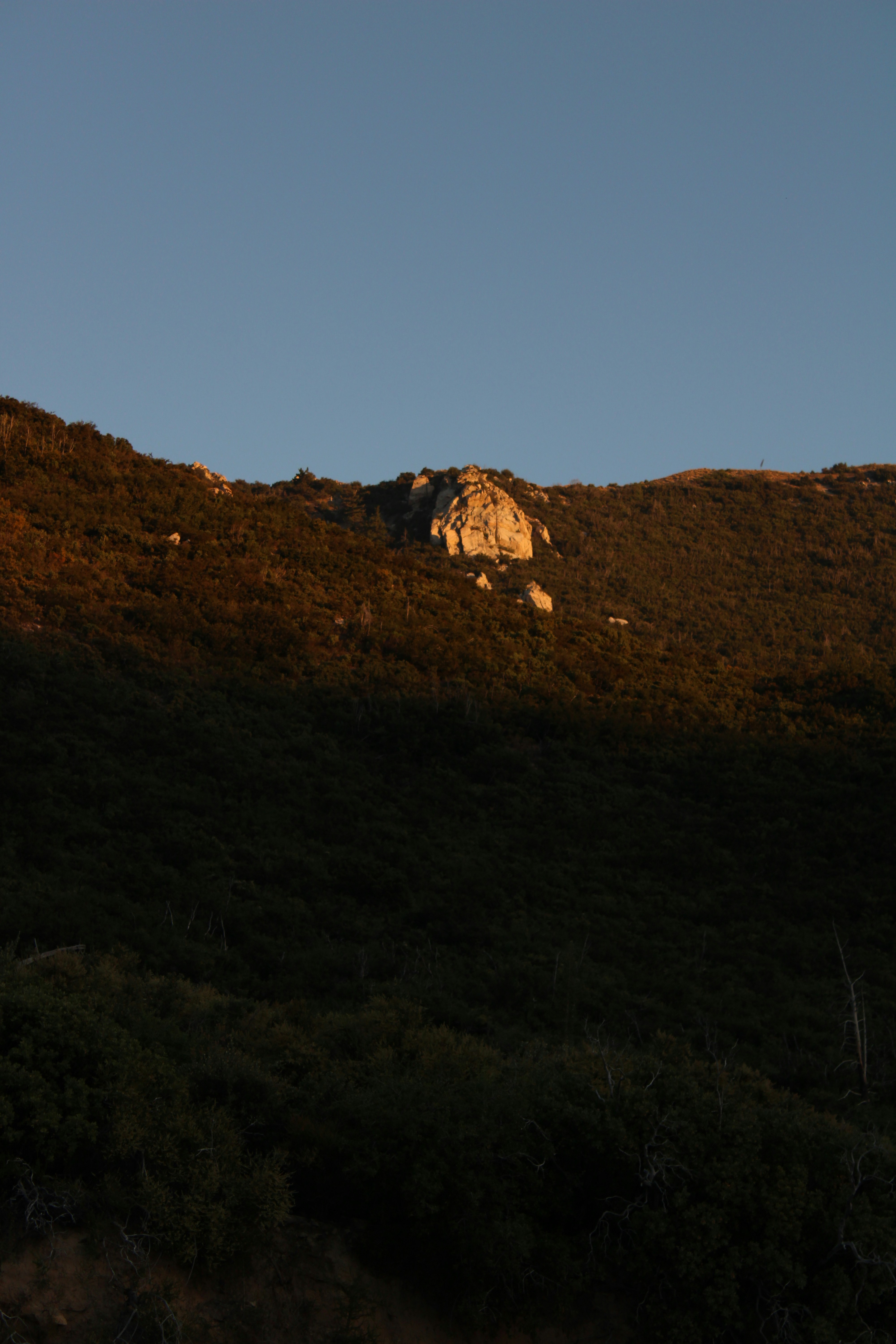 ein Hügel mit einem großen Felsen darauf