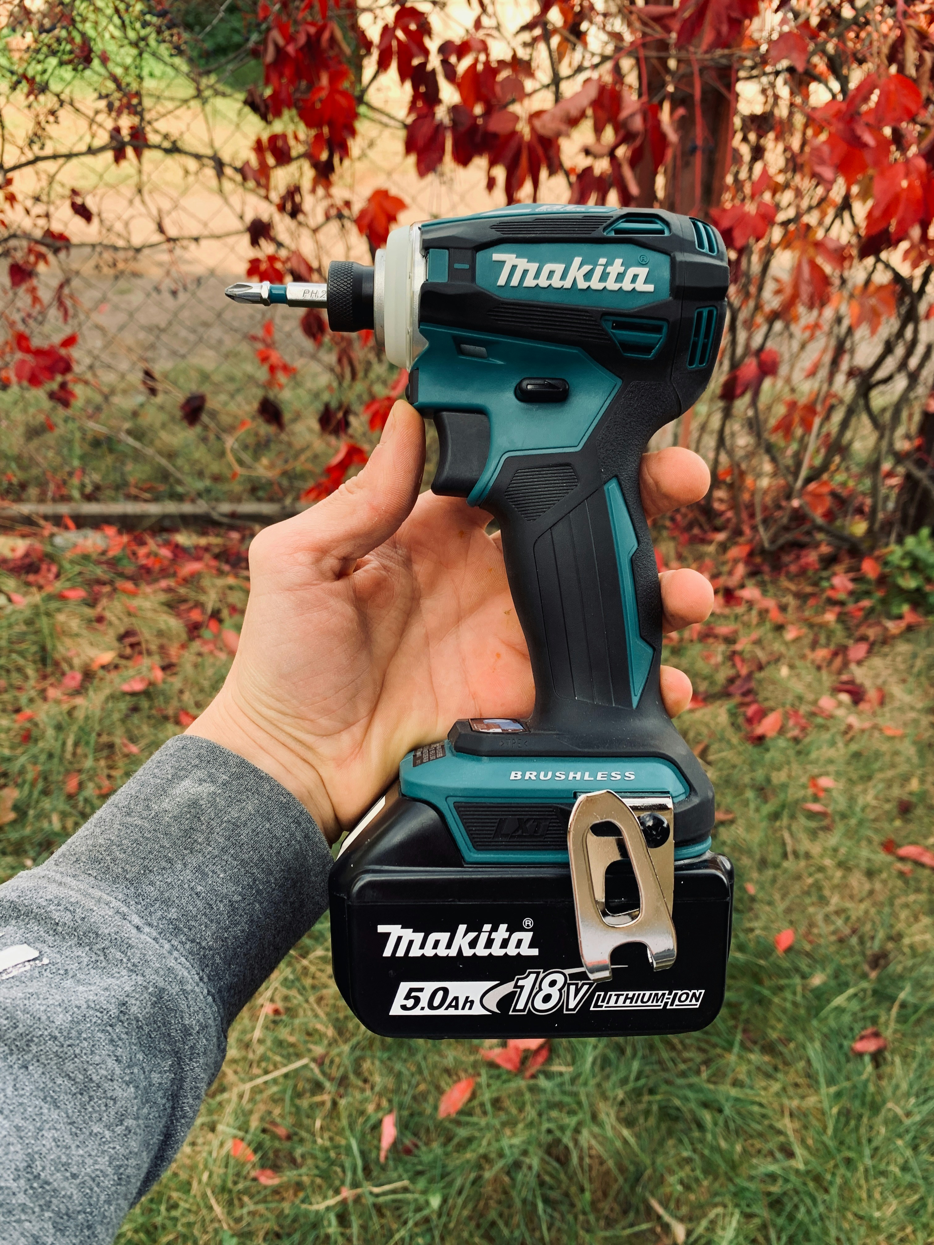 a person holding a cordless drill in their hand