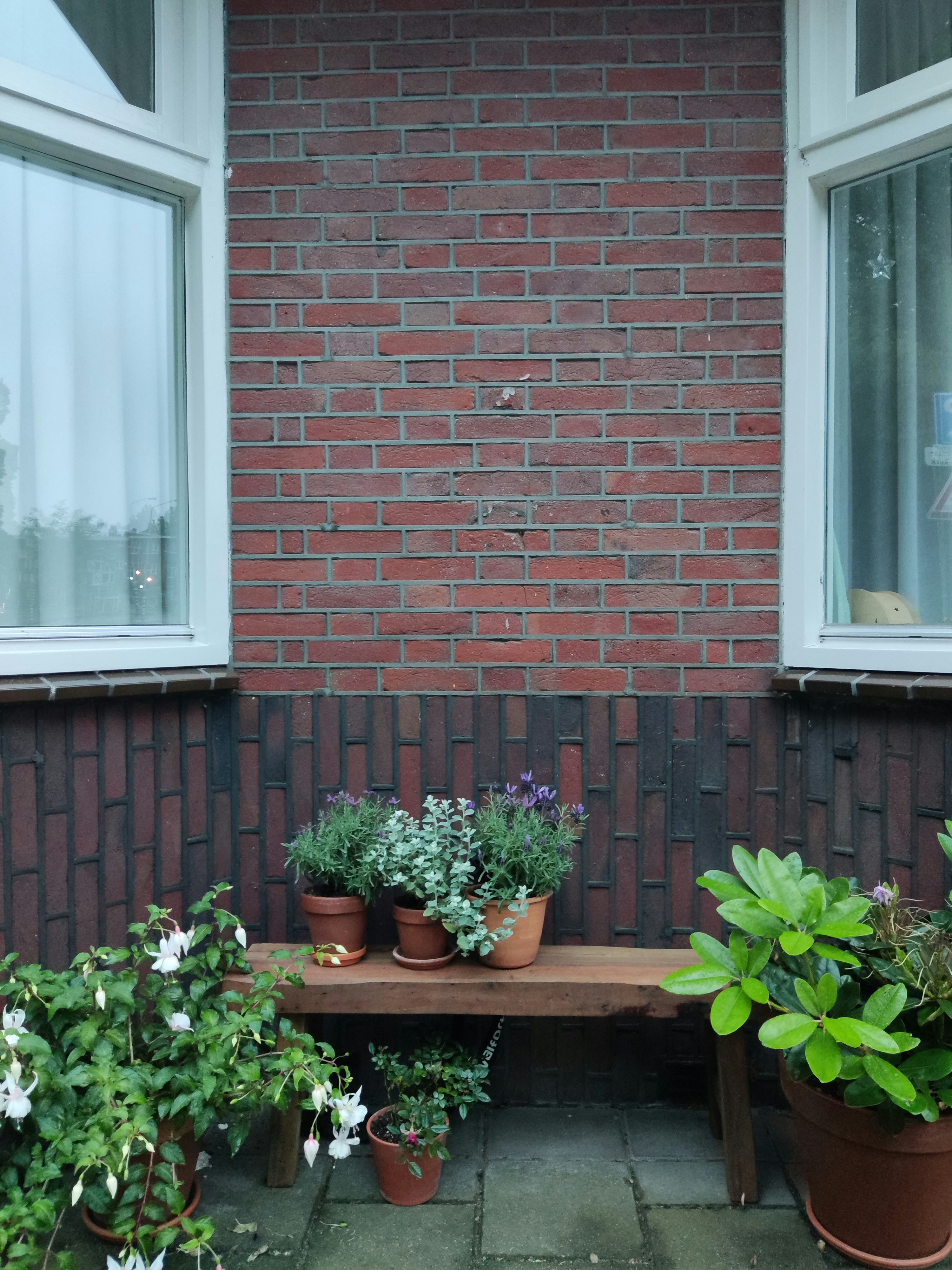 a wooden bench sitting in front of a brick building