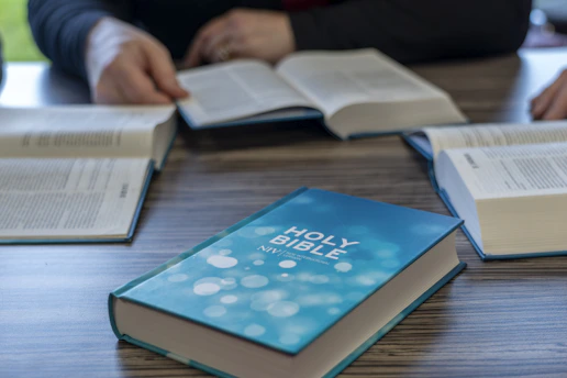 two people sitting at a table with open books