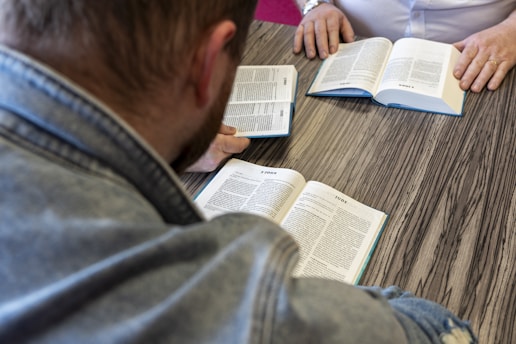 a man sitting at a table reading a book