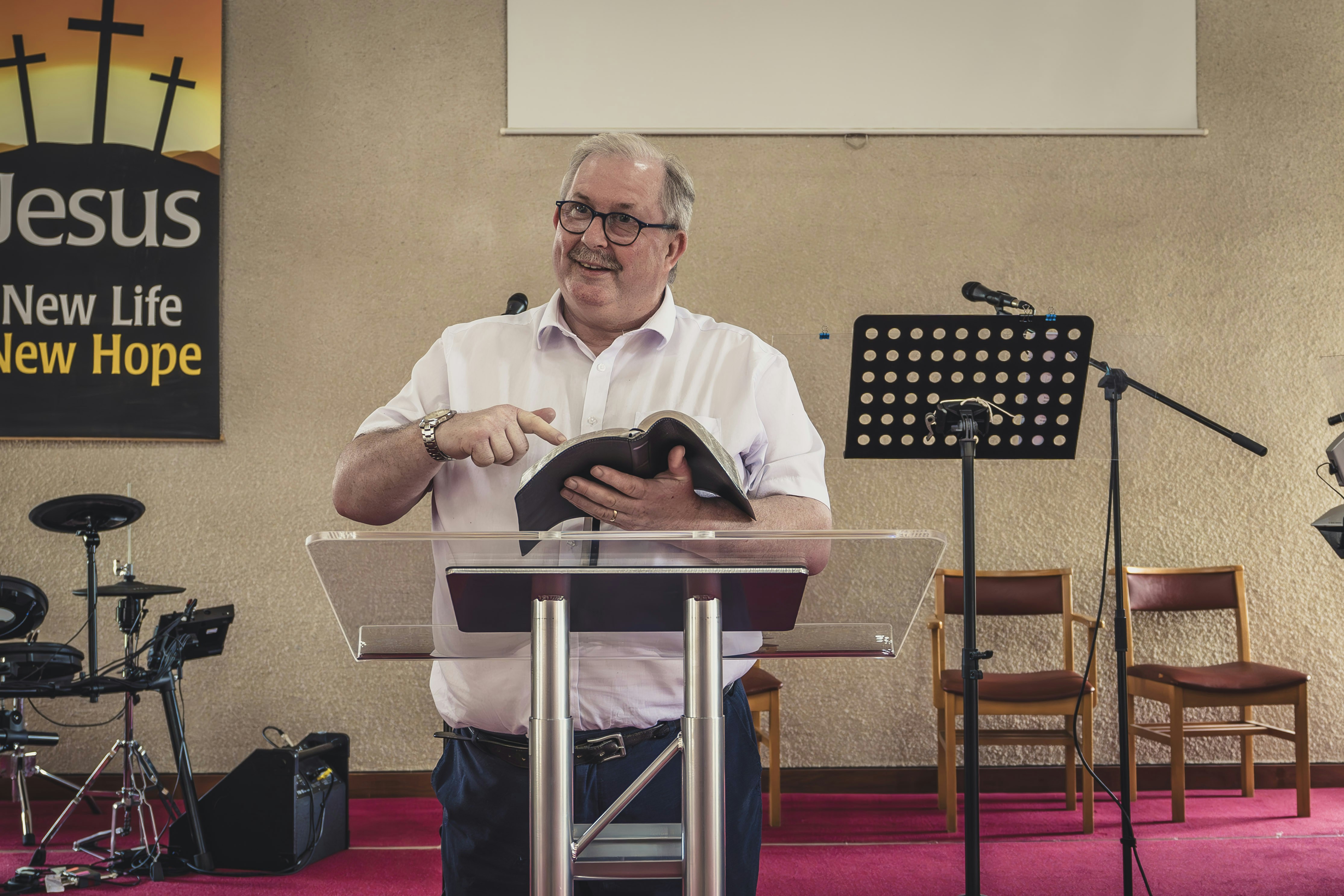 a man standing at a podium in front of microphones