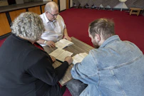 a group of people sitting around a wooden table