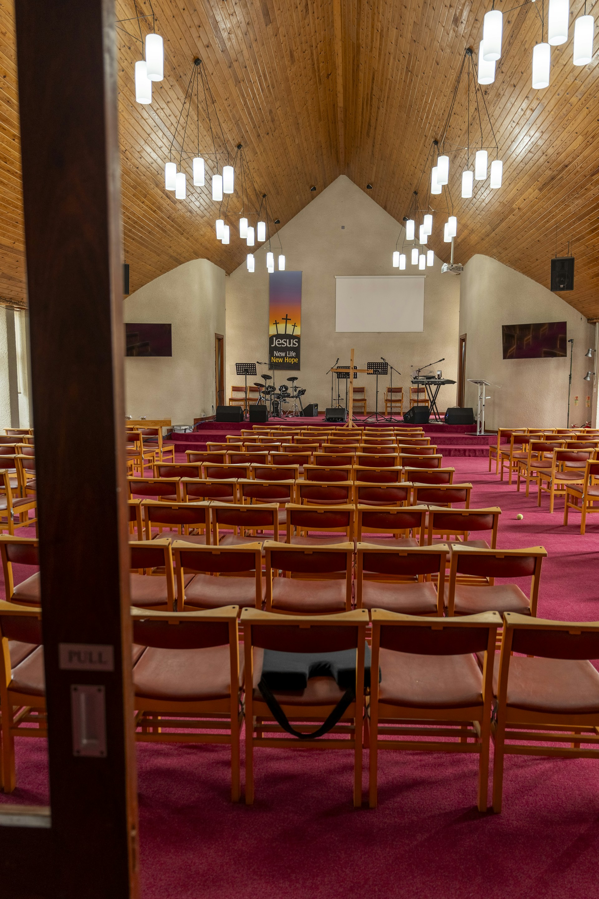 a church filled with lots of chairs and a projector screen