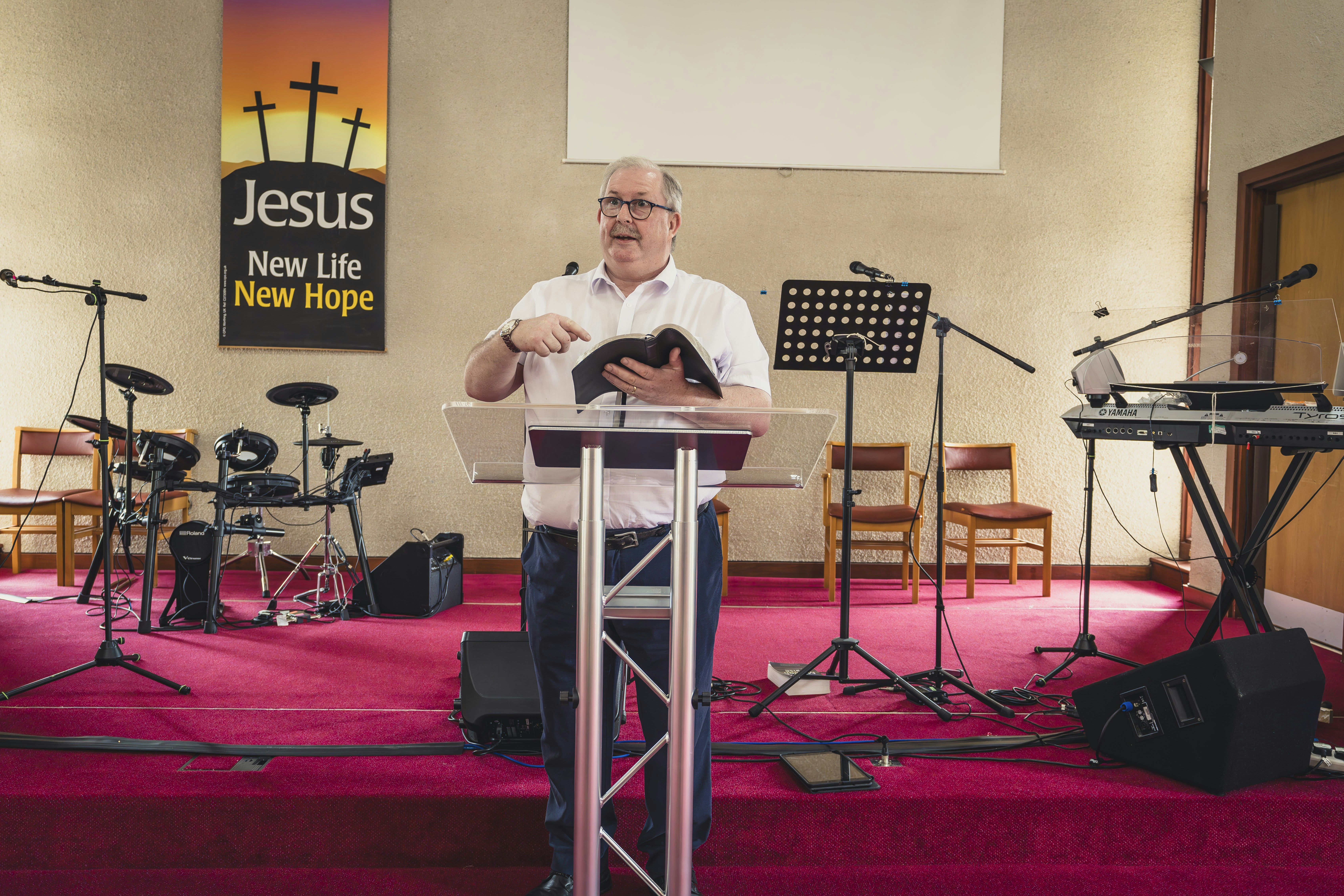 a man standing at a podium in front of a microphone
