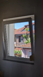 a window with a view of a house in the background