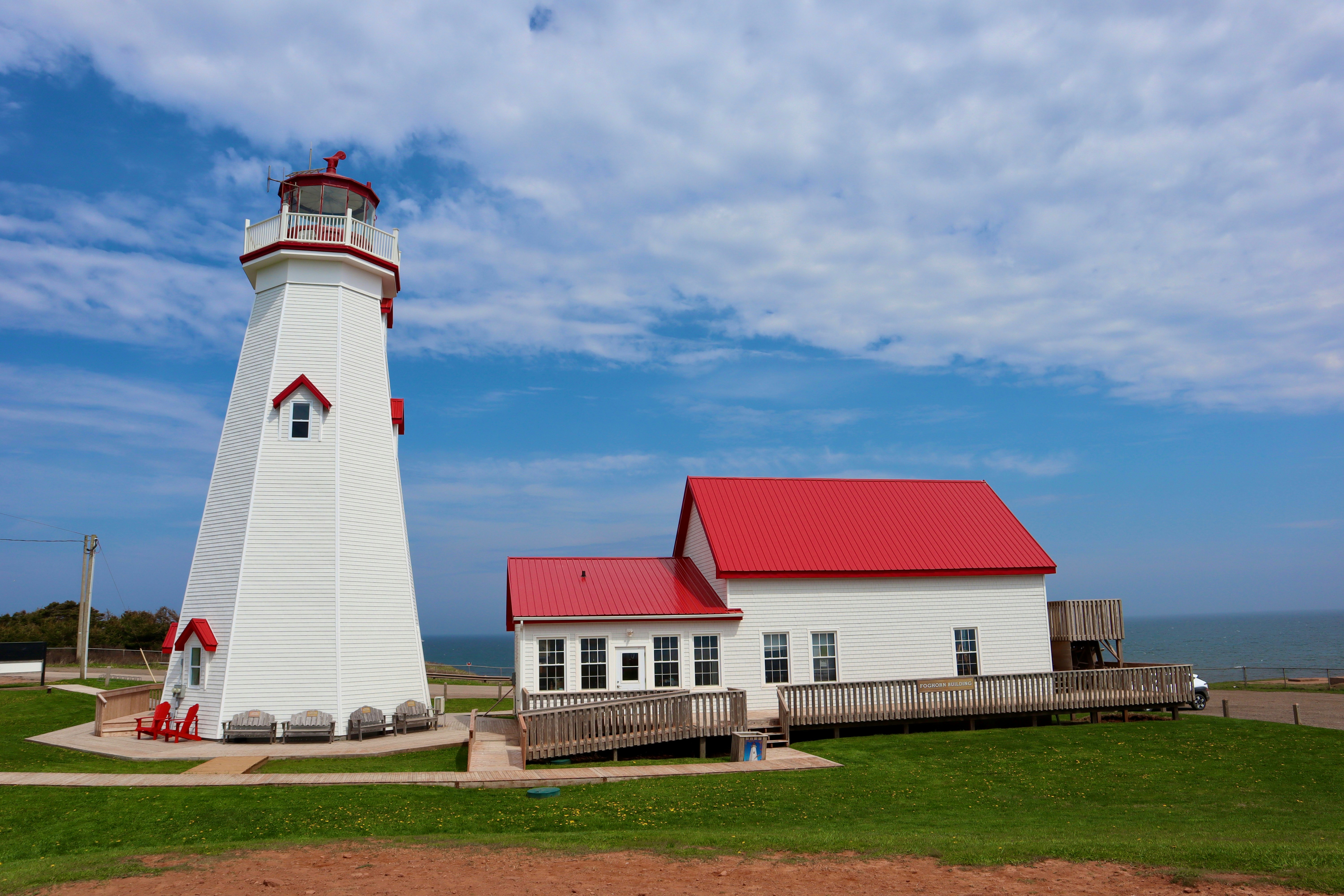 a white lighthouse with a red roof and a red roof