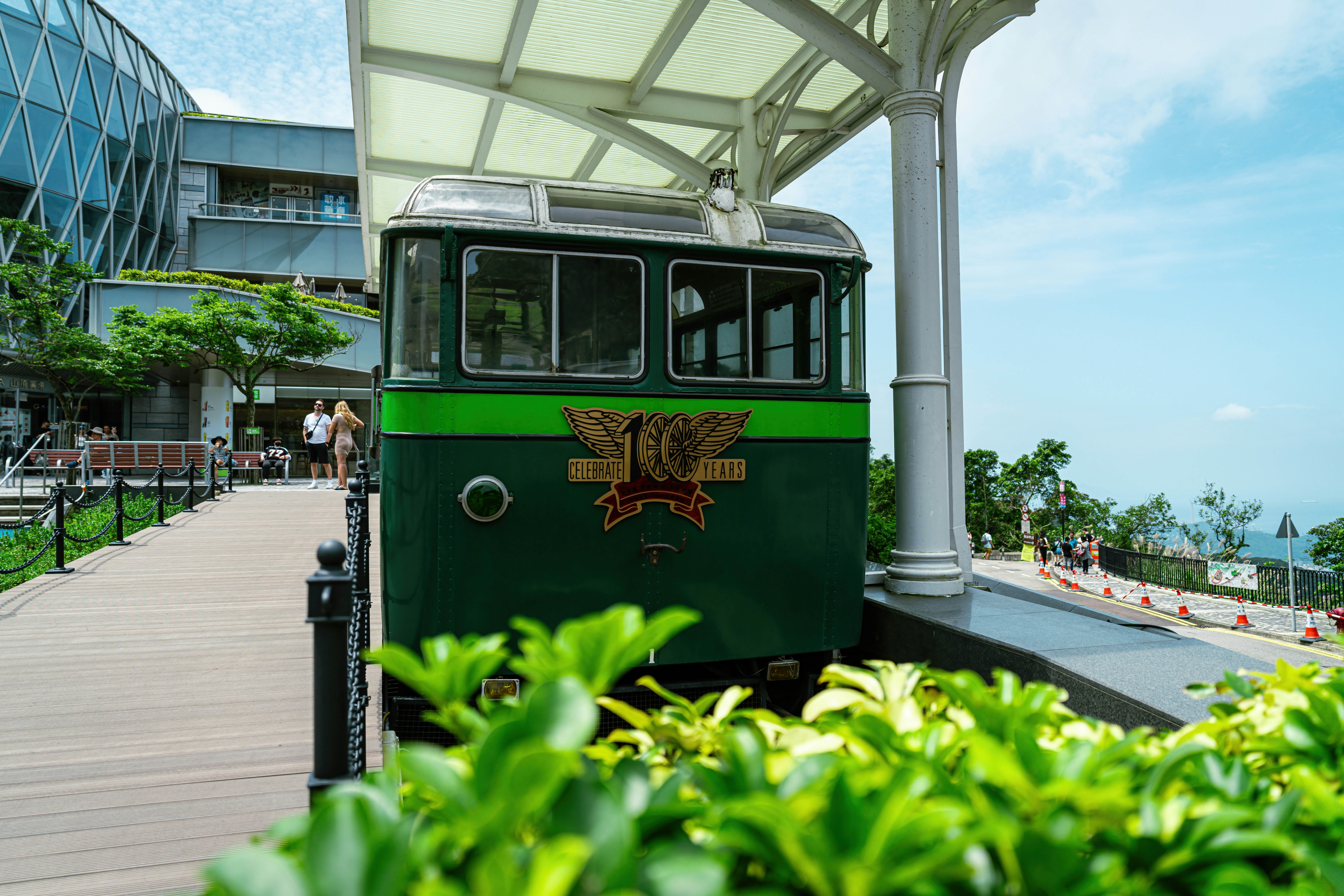 un treno verde e bianco su un binario accanto a un edificio