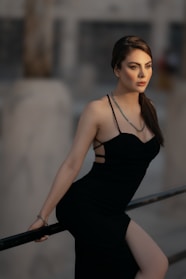 a woman in a black dress posing for a picture