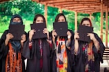 a group of women holding up black paper