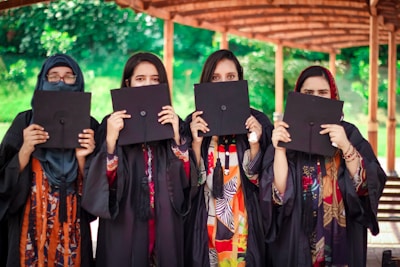 a group of women holding up black paper