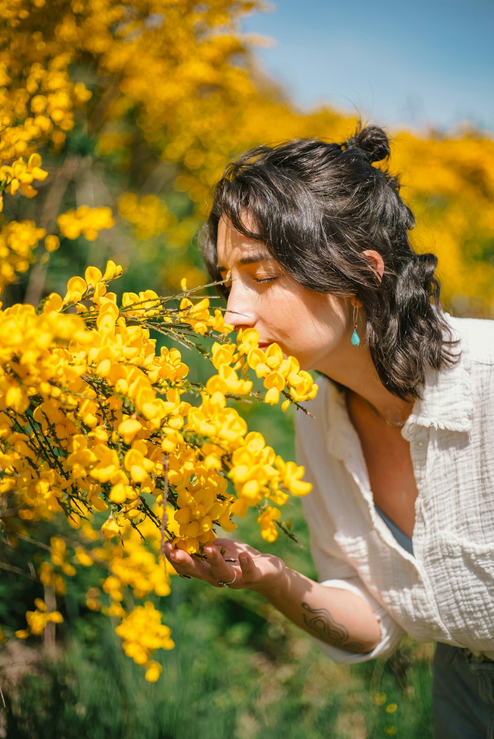 a woman smelling a bunch of yellow flowers