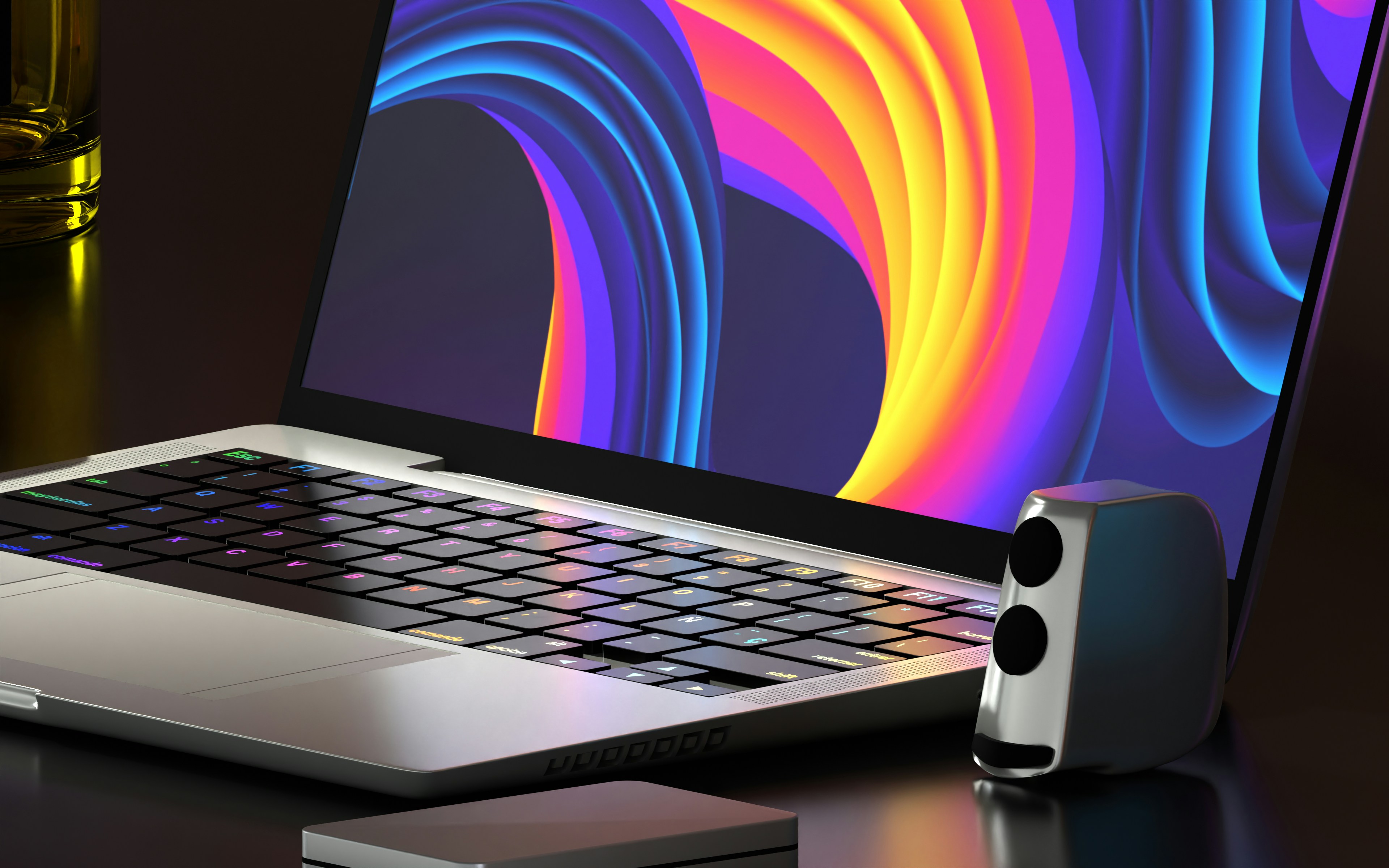 Laptop with a colourful wallpaper beside a speaker