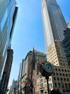 a city street with tall buildings and a clock