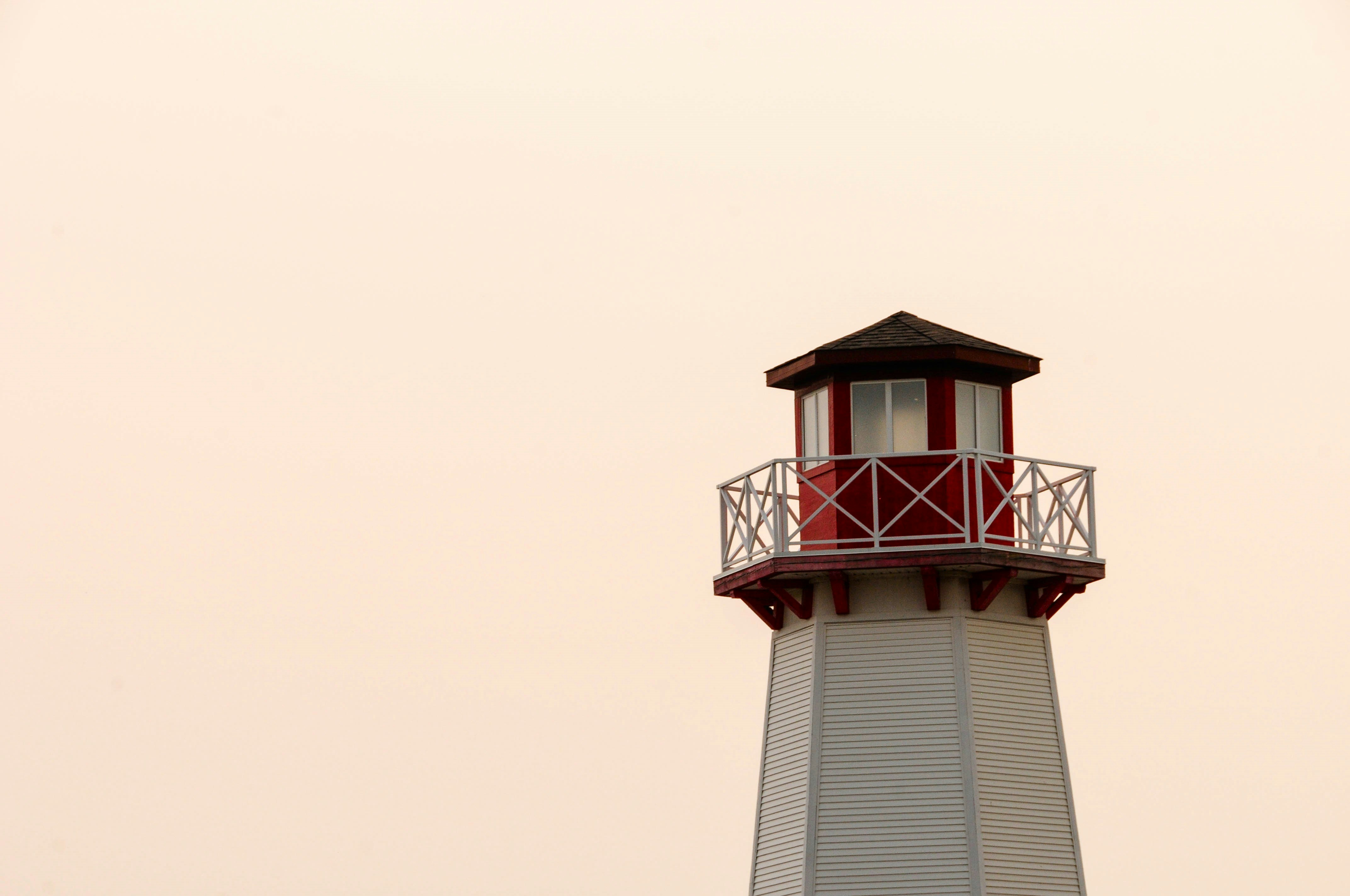 a red and white light house with a balcony
