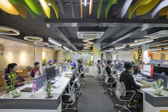 a group of people sitting at desks in an office
