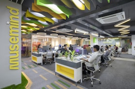 a group of people sitting at desks in an office