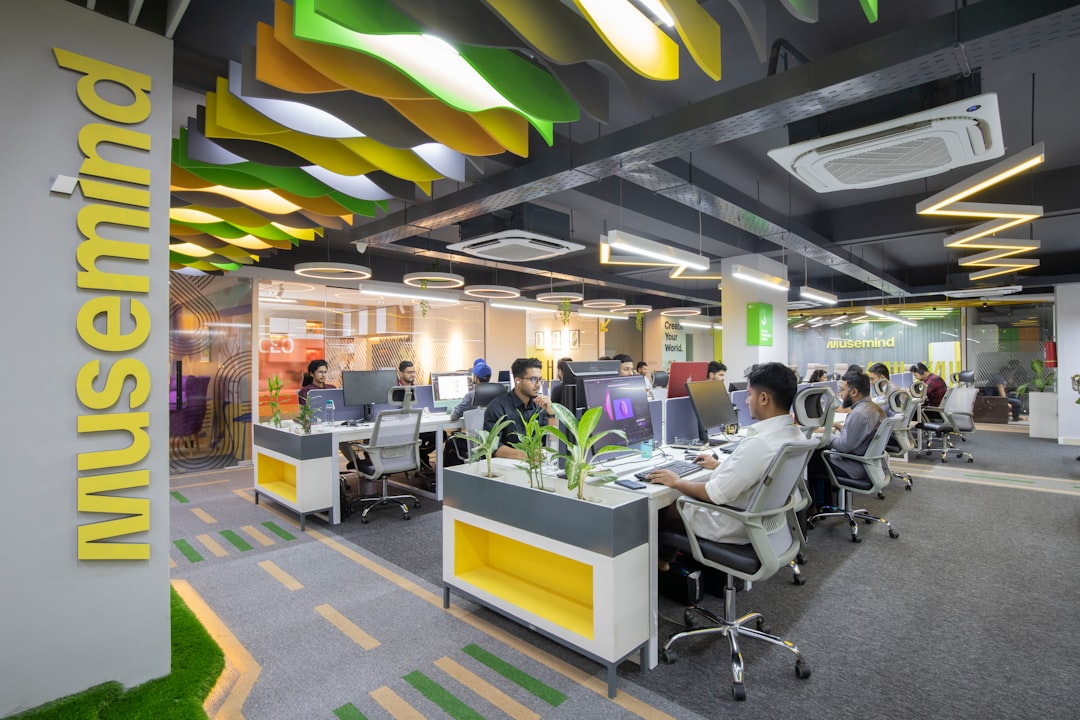 a group of people sitting at desks in an office,