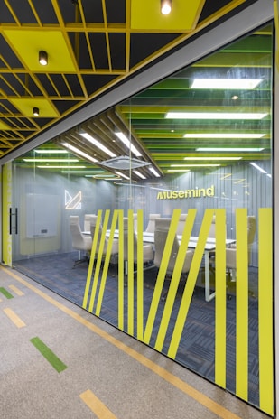 an office with yellow and black accents and a glass wall