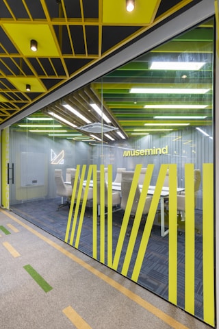 an office with yellow and black accents and a glass wall