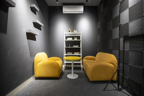 a yellow chair and two yellow chairs in a room