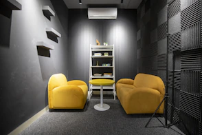 a yellow chair and two yellow chairs in a room