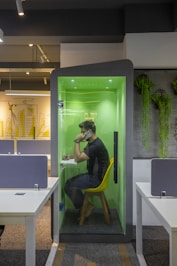 a man sitting at a table in a green room