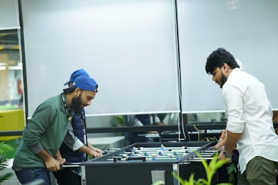 two men playing a game of foo - pong in an office