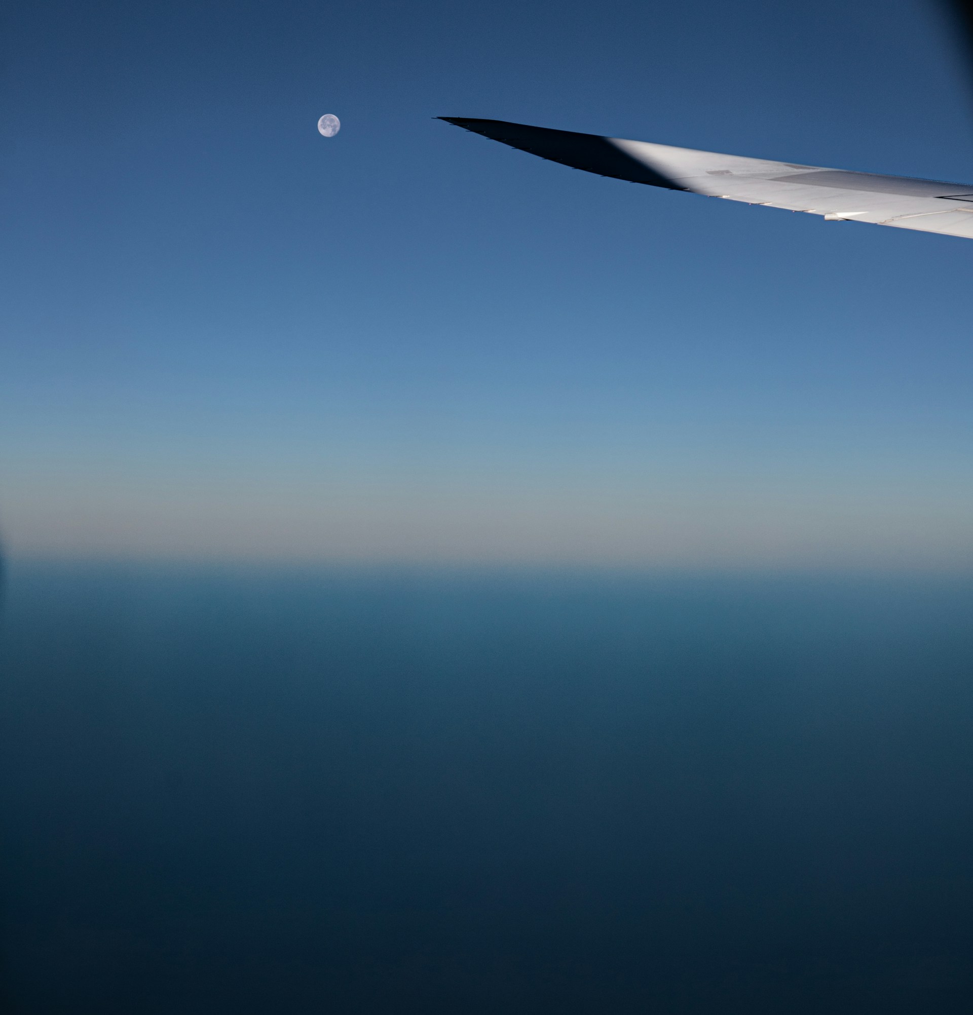 the wing of an airplane flying over the ocean