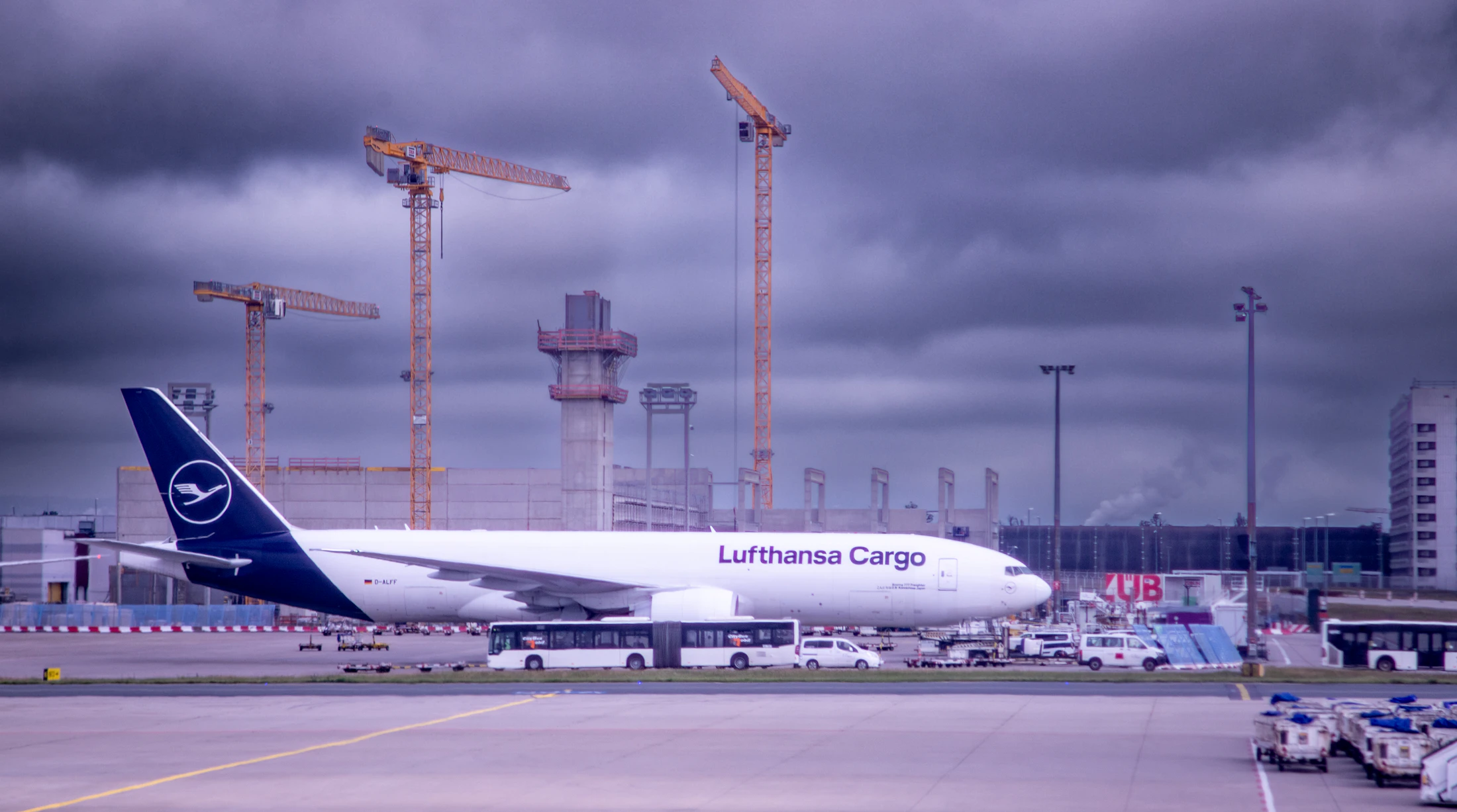 Cargo aircraft on the tarmac with ground support crew and vehicles, representing global logistics