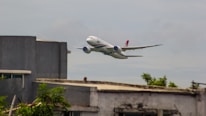an airplane is flying low over a building