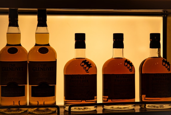a row of bottles of whiskey sitting on a shelf