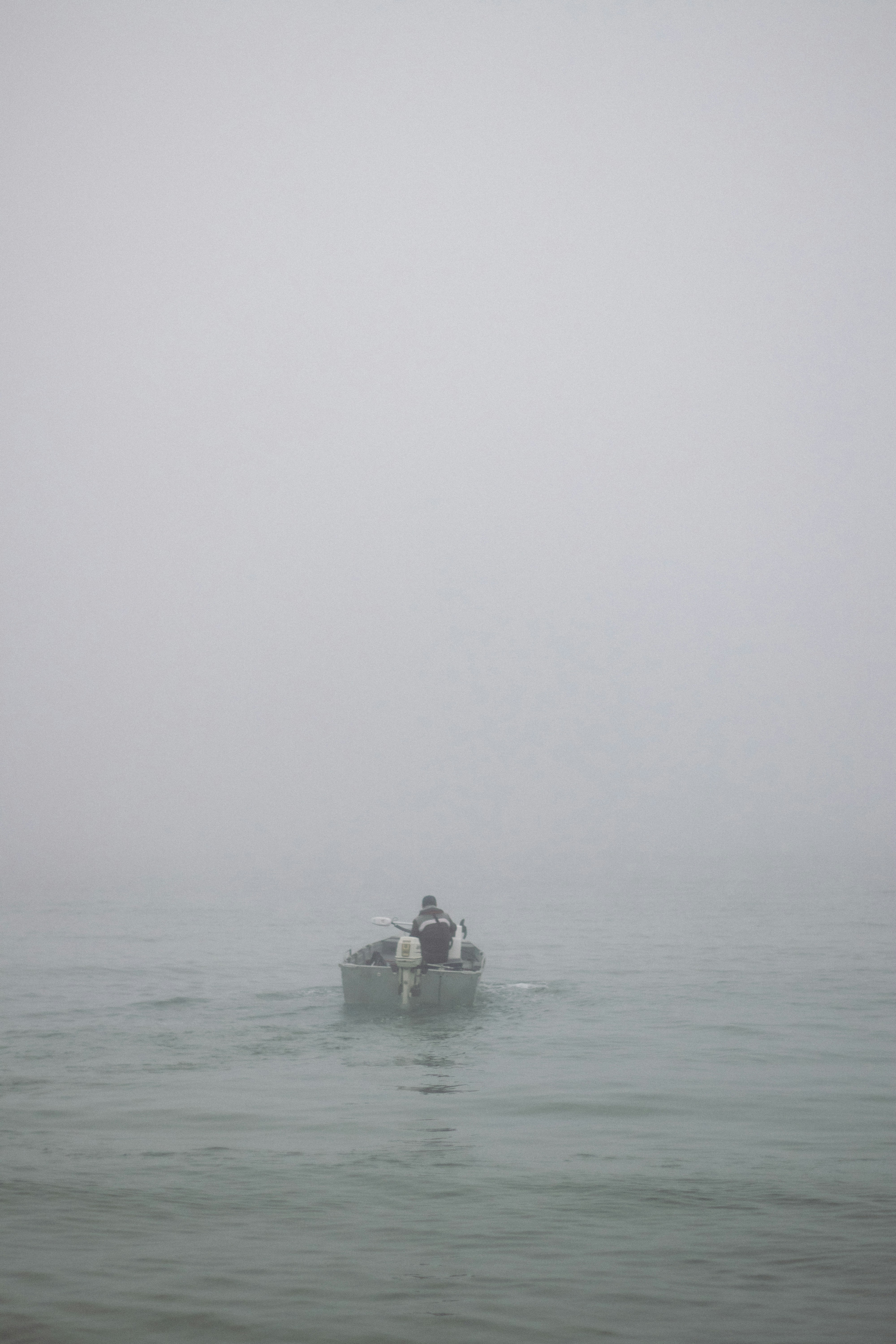 Due persone in una piccola barca in una giornata nebbiosa