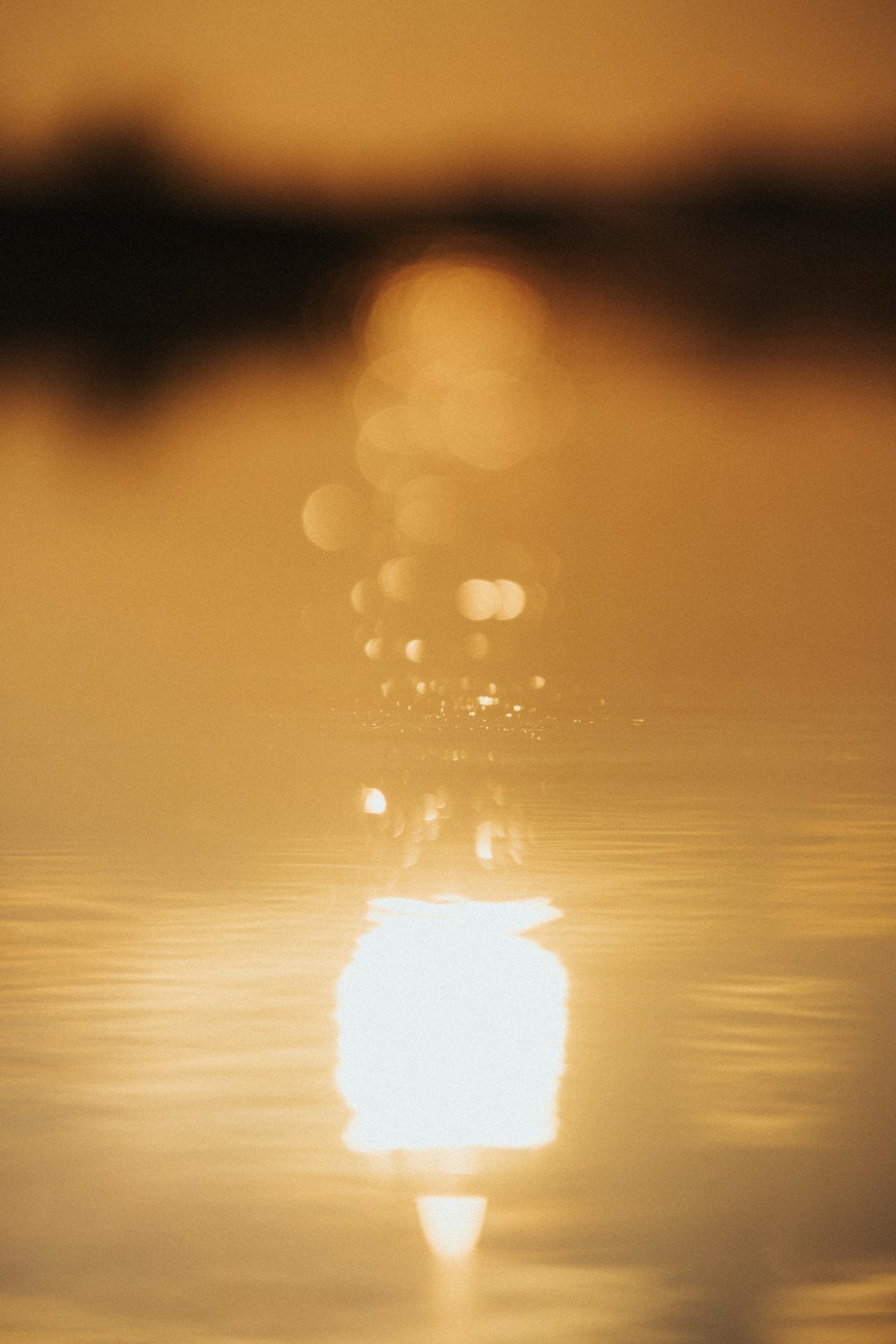 a blurry photo of the sun reflecting in the water