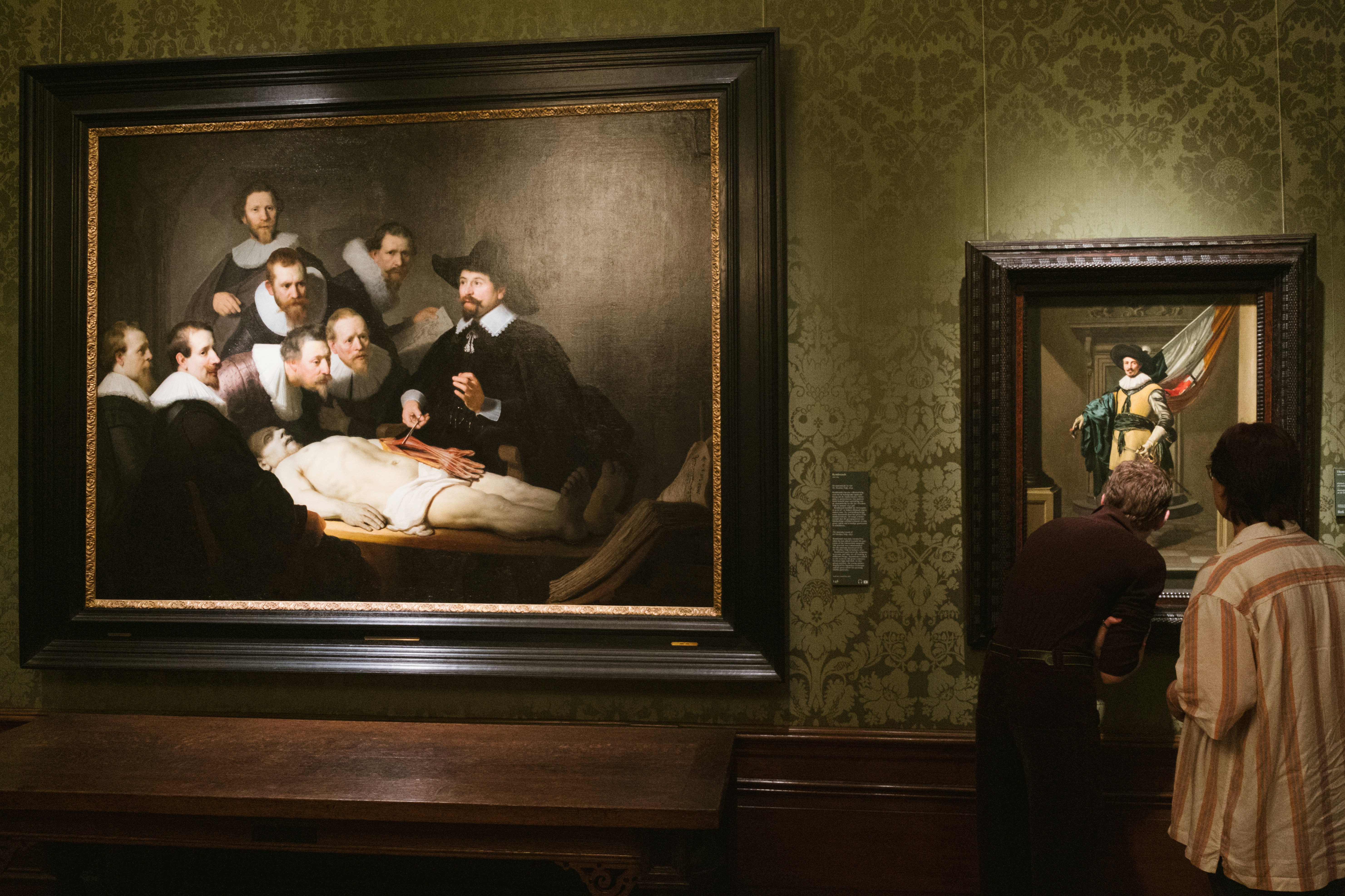 a group of people looking at a painting in a museum