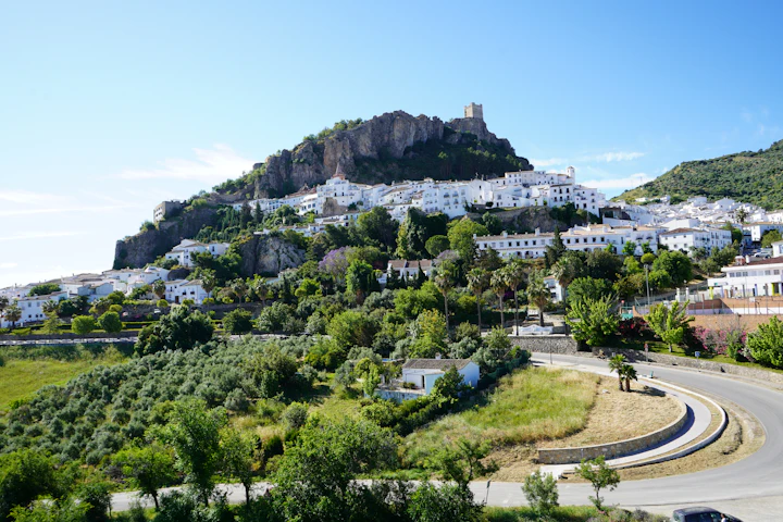 Auto op een weg langs groene heuvels in Andalusië