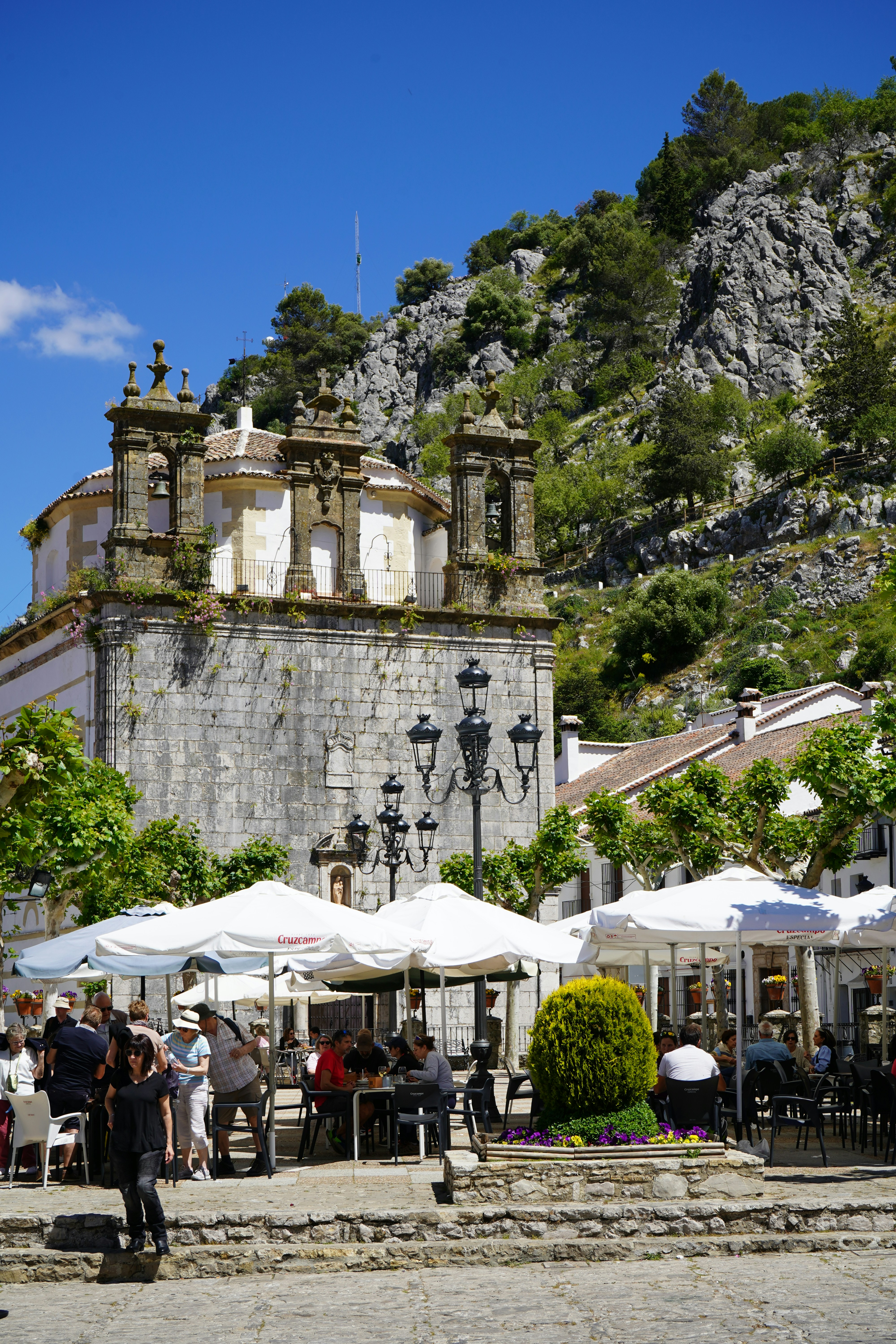 um grupo de pessoas sentadas em mesas sob guarda-chuvas
