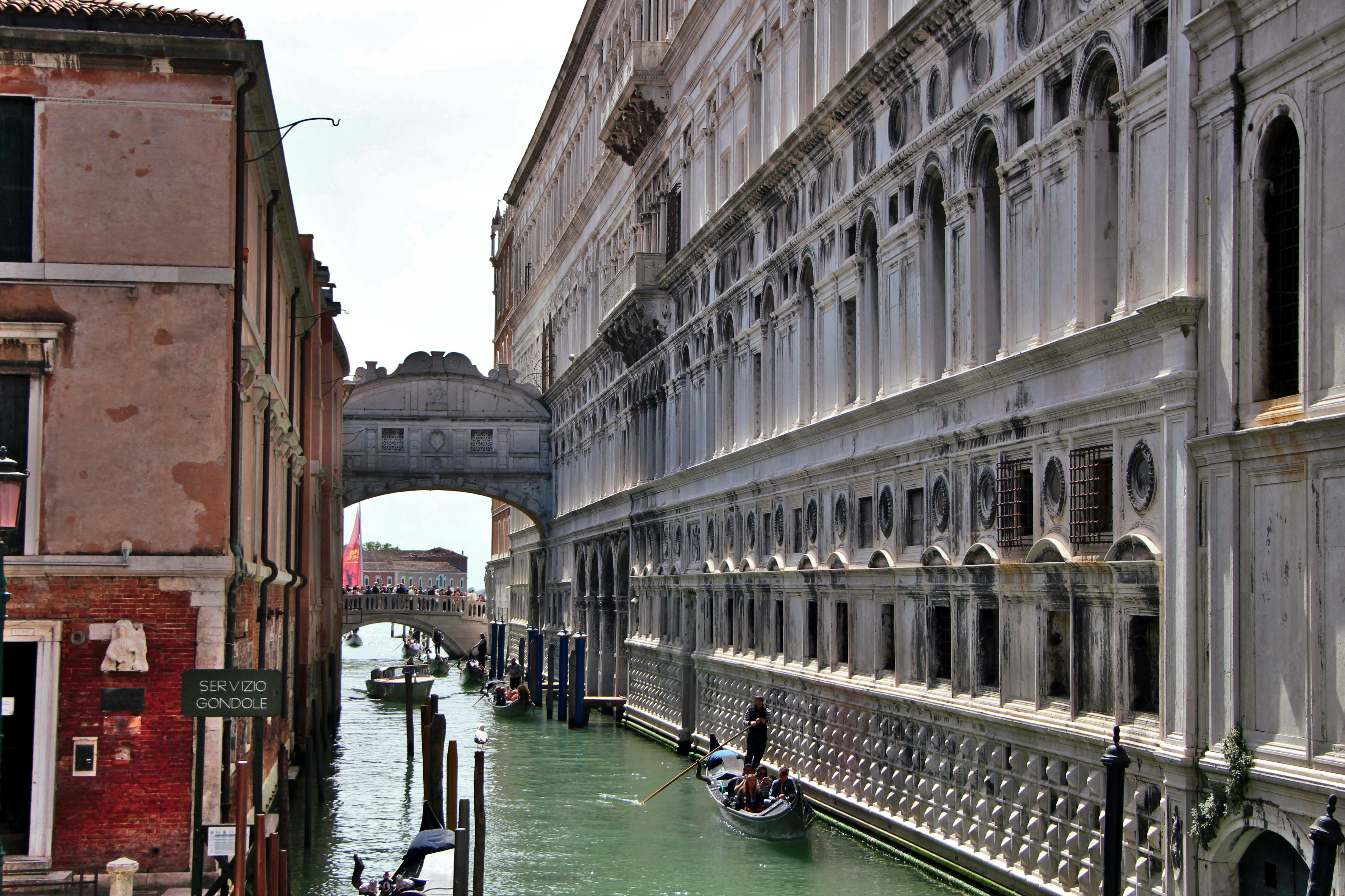 a narrow canal with a bridge in the background
