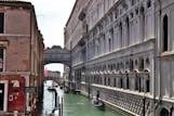 a narrow canal with a bridge in the background