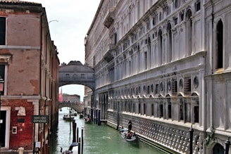 a narrow canal with a bridge in the background